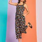 Woman jumping in novelty fruit print cropped jumpsuit