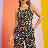 Woman wearing retro black fruit print jumpsuit with pockets
