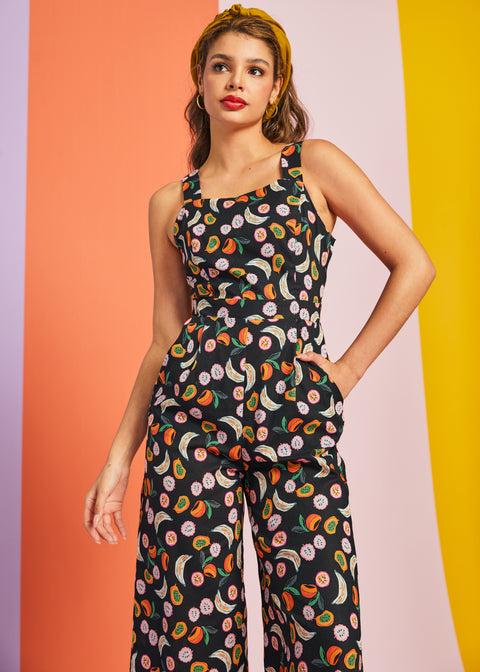 Woman wearing retro black fruit print jumpsuit with pockets