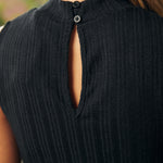 Close-up of back keyhole detail and mock neckline on black ribbed knit top