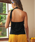 Back view of black sleeveless halter top with open back silhouette and tie neck detail