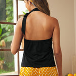 Back view of black sleeveless halter top with open back silhouette and tie neck detail