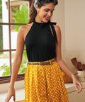 Woman wearing vintage-inspired black halter knit top with polka dot skirt
