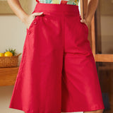 Person wearing a colorful top and red shorts in an indoor setting.