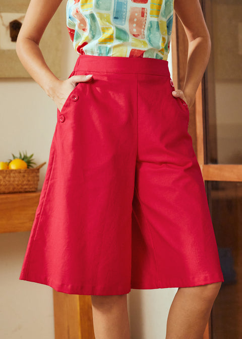 Person wearing a colorful top and red shorts in an indoor setting.