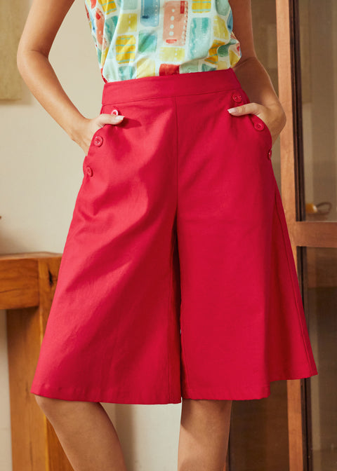 Person wearing a colorful top and red skort in an indoor setting
