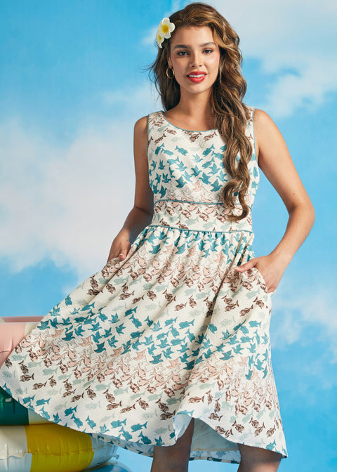 Woman wearing a nautical fish print dress against a blue sky background