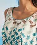Close-up of rounded neckline with contrast piping on novelty print dress