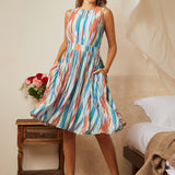 Woman wearing multicolor striped sleeveless fit and flare dress with flowing skirt