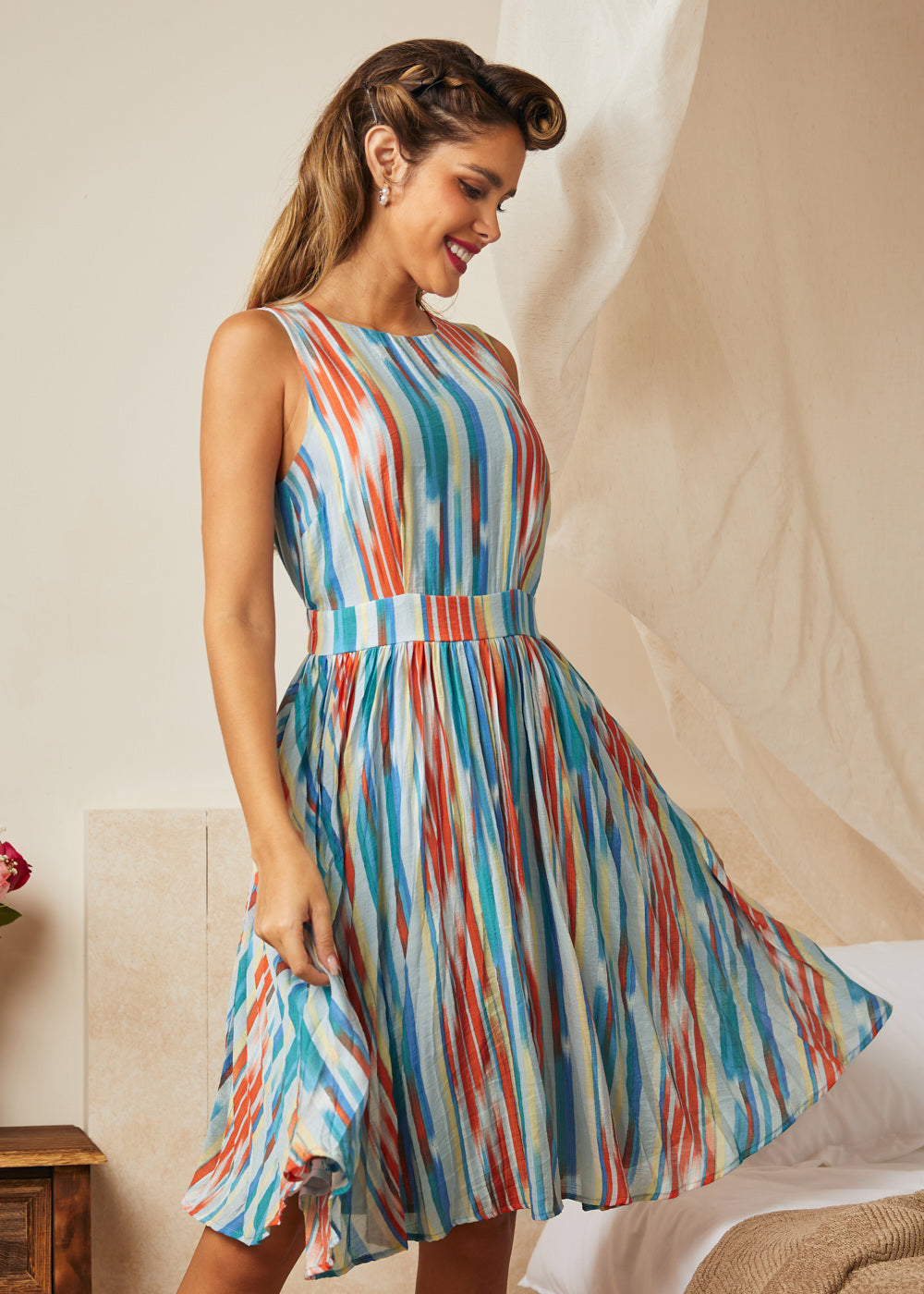 Woman twirling in retro-inspired watercolor stripe dress with pockets