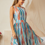 Woman twirling in retro-inspired watercolor stripe dress with pockets