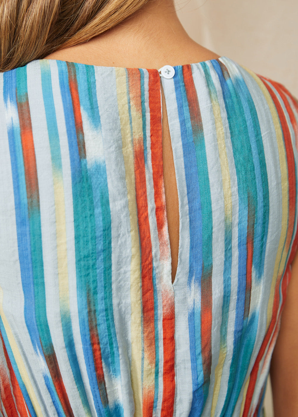 Close-up back detail of striped dress with button keyhole closure