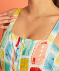 Close-up of square neckline and watercolor patchwork print on cotton sundress