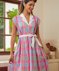 Woman wearing a colorful plaid vintage style dress in a kitchen setting