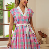 Woman wearing a colorful plaid vintage style dress in a kitchen setting