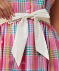 Close-up of waist tie bow detail on plaid dress with hearts
