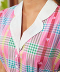 Close-up of contrast collar and button-front bodice on woman's plaid dress