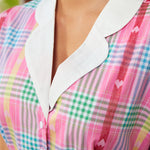Close-up of contrast collar and button-front bodice on woman's plaid dress
