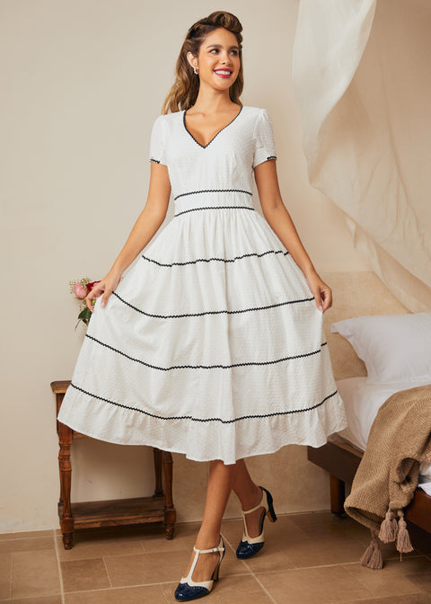 Full-length view of white fit-and-flare dress styled with vintage-inspired heels