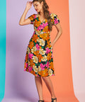 Woman wearing colorful retro black floral midi dress with puff sleeves and pockets