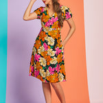Woman wearing colorful retro black floral midi dress with puff sleeves and pockets