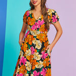 Woman wearing a colorful floral dress against a gradient background