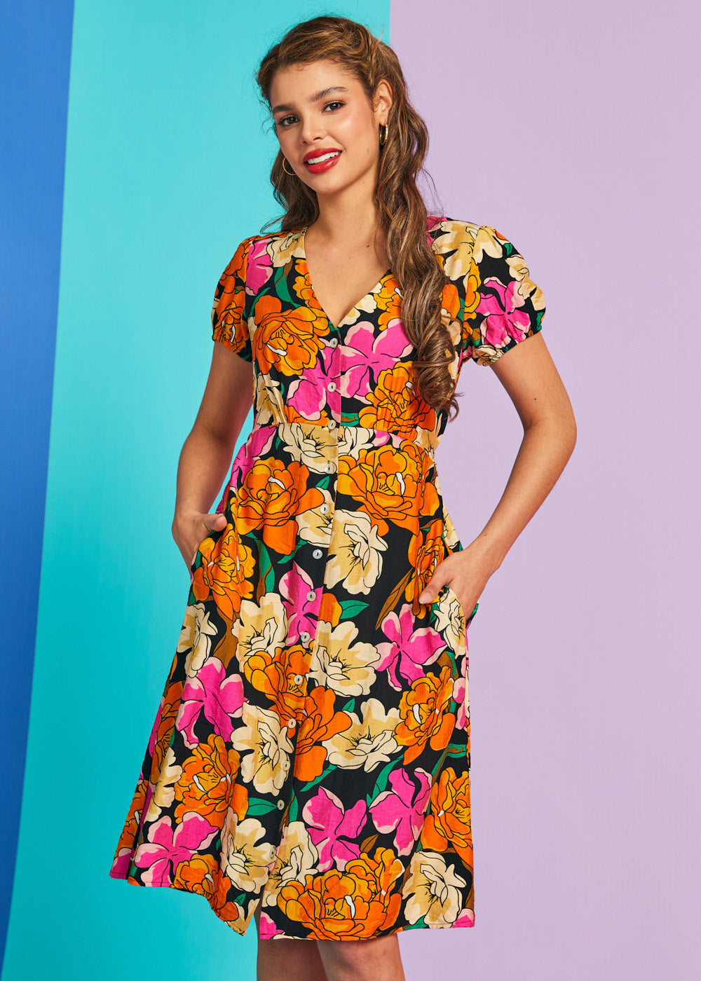 Woman wearing a colorful floral dress against a gradient background
