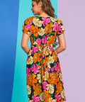 Back view of bright orange and hot pink floral midi dress with waist tie detail