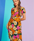 Woman wearing retro mod floral puff sleeve midi dress with v-neckline