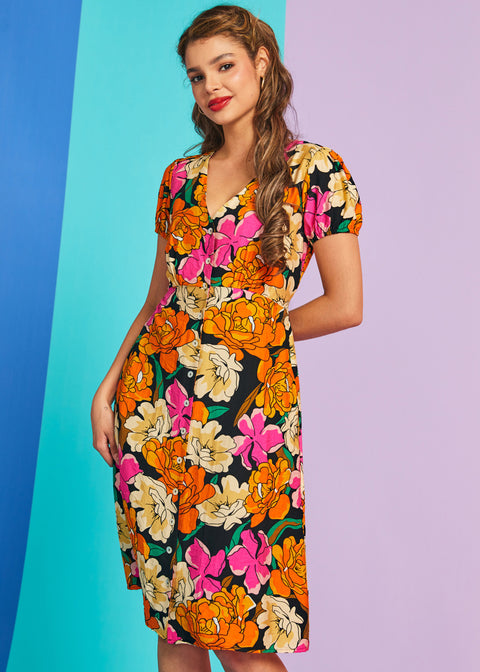 Woman wearing retro mod floral puff sleeve midi dress with v-neckline