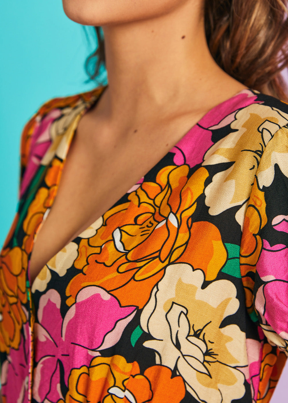 Close-up of dress bodice with oversized orange and pink floral print on black fabric