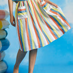 Woman twirling in retro-inspired multicolor stripe dirndl skirt with full gathered silhouette