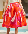 Model wearing abstract sunset print midi skirt, front view with gathered waist