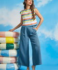 Woman wearing vintage-inspired pastel stripe boatneck top with wide-leg blue trousers