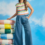 Woman wearing vintage-inspired pastel stripe boatneck top with wide-leg blue trousers