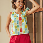 Sleeveless blouse with colorful abstract print and shoulder bow detail front view