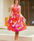 Model wearing abstract pink and orange halter crop top with matching skirt, front view