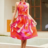 Model wearing abstract pink and orange halter crop top with matching skirt, front view