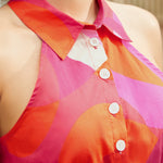 Close-up of collared halter neckline with button-front detail in abstract print