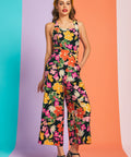 Woman wearing retro floral wide-leg jumpsuit with square neckline and cropped silhouette in bloom print