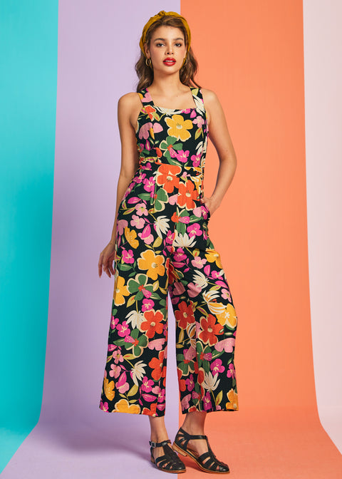 Woman wearing retro floral wide-leg jumpsuit with square neckline and cropped silhouette in bloom print