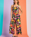 Woman wearing retro-inspired floral cropped jumpsuit with wide-leg silhouette and pockets