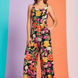 Woman wearing retro-inspired floral cropped jumpsuit with wide-leg silhouette and pockets