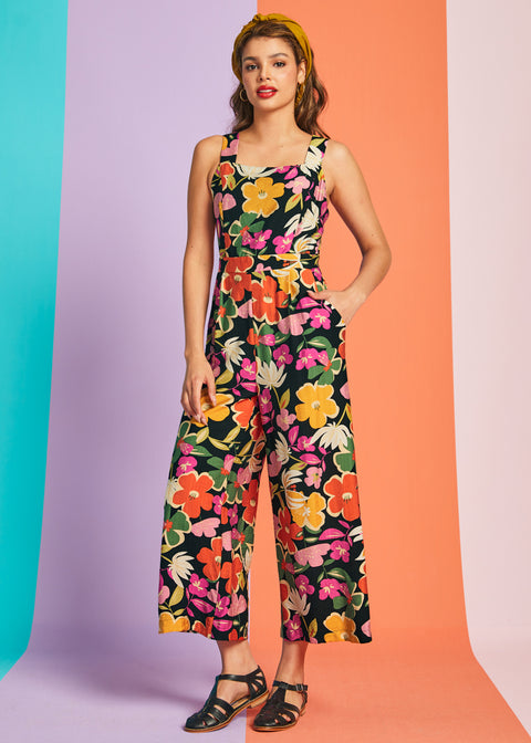 Woman wearing retro-inspired floral cropped jumpsuit with wide-leg silhouette and pockets