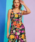 Woman posing in colorful floral jumpsuit with square neckline and relaxed fit