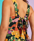 Back detail of floral wide-leg jumpsuit featuring oversized self-tie bow and elasticized waist