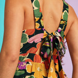 Back detail of floral wide-leg jumpsuit featuring oversized self-tie bow and elasticized waist