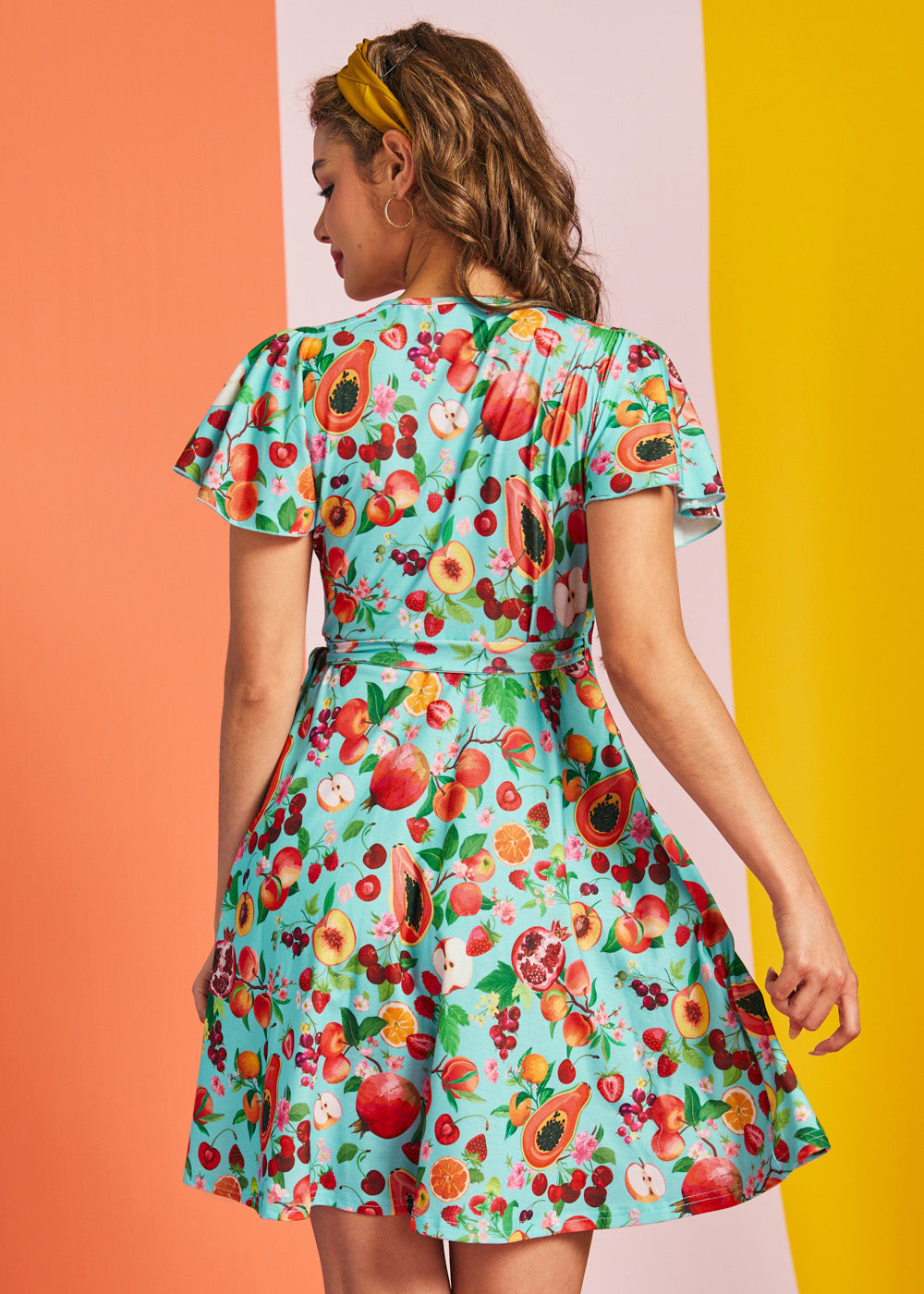 Back view of aqua fruit print wrap mini dress with short flutter sleeves