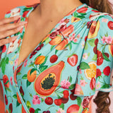 Close-up of colorful fruit print fabric featuring papaya, cherries, peaches, and citrus