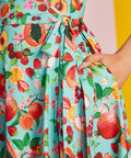 Close-up of self-tie waist and fruit novelty print on aqua fabric